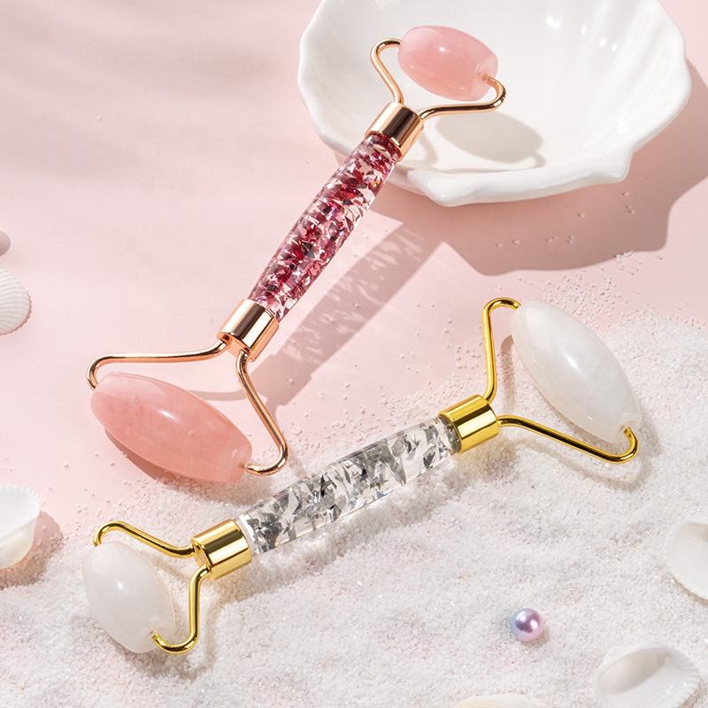 lireth. rose quartz and white jade facial rollers on pink sand